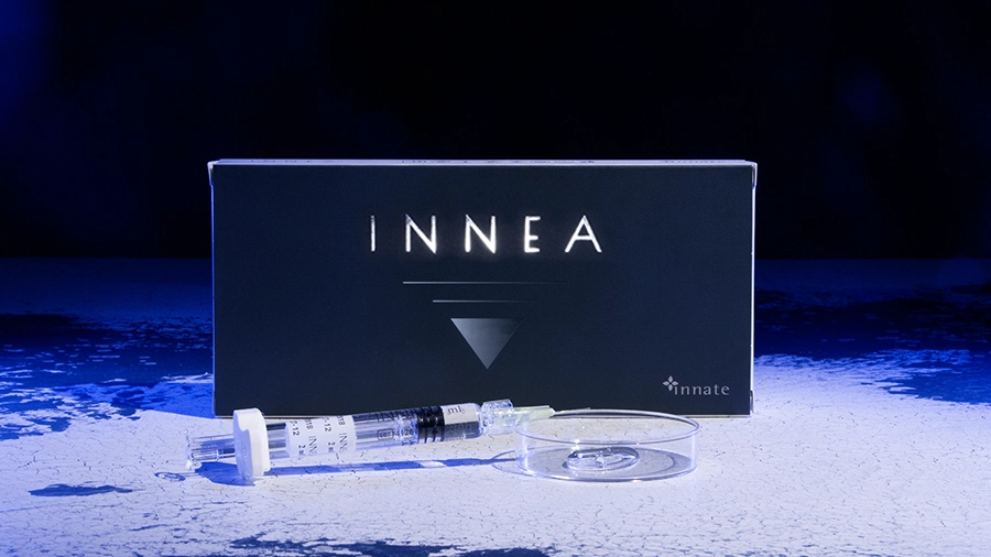 INNEA Classic product packaging with syringe and petri dish under blue-toned lighting. Conveys essential care and scientific rigor in aesthetic treatments.